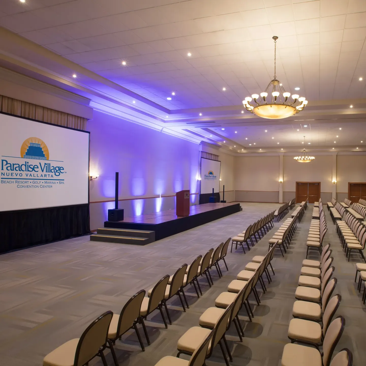 Conference room with stage and rows of chairs at Paradise Village Beach Resort and Spa.