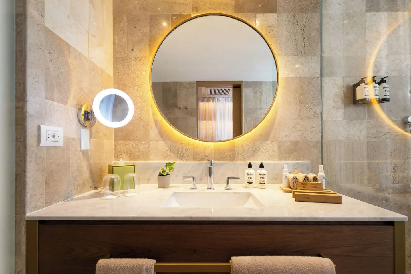 Close view of a bathroom vanity with round mirror and amenities at Paradisus Cancún.