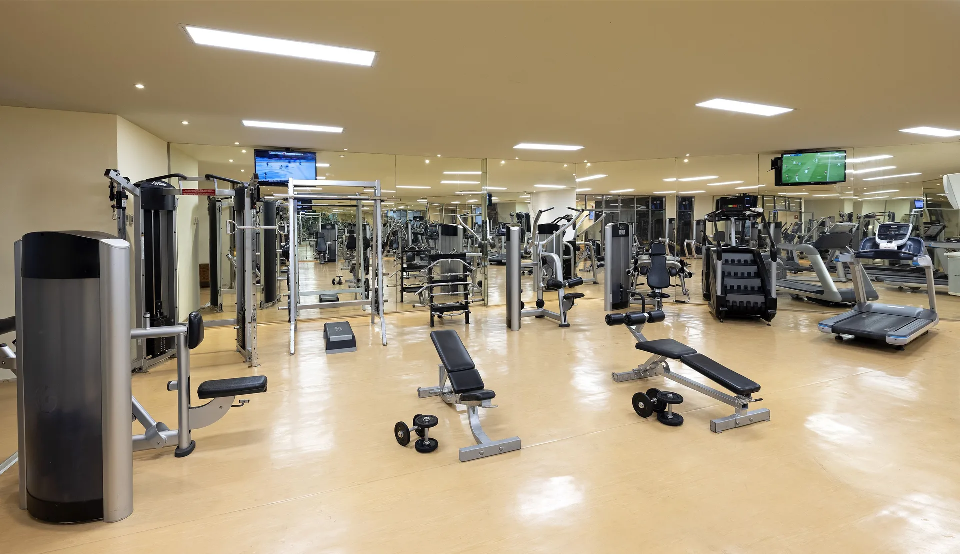 Fitness center strength machines, benches, dumbbells, and treadmills at Paradisus Cancún.