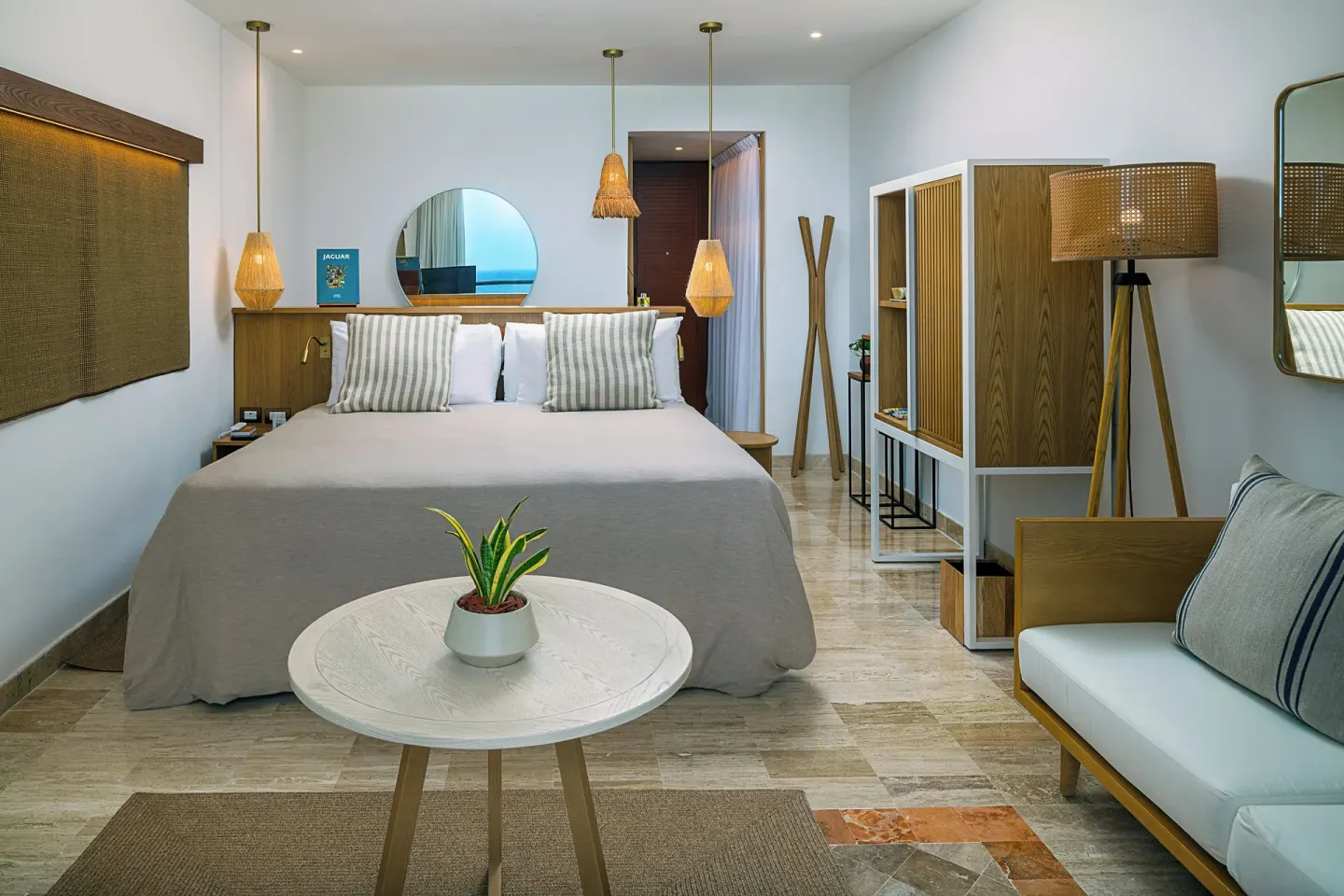 Guest room with king bed, bench seating and woven lighting at Paradisus Cancún.