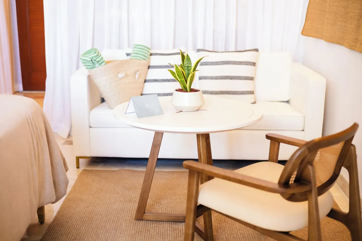 Guest room seating nook with sofa, round table, and lounge chair at Paradisus Cancún.