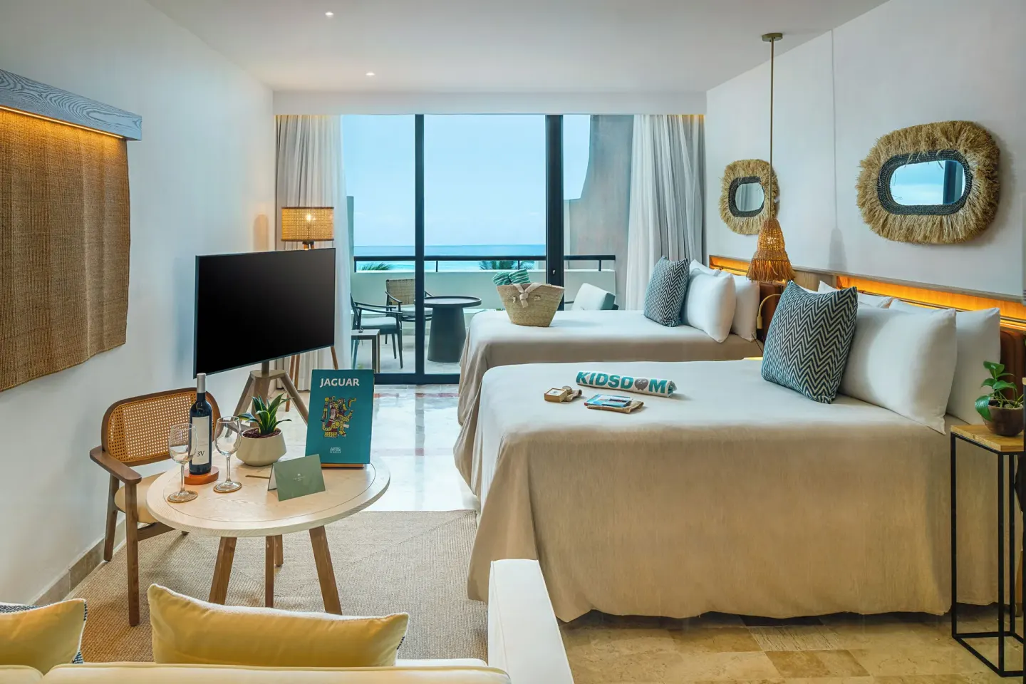 Guest room with two beds at Paradisus Cancún, seating area, TV, and balcony doors to the ocean.