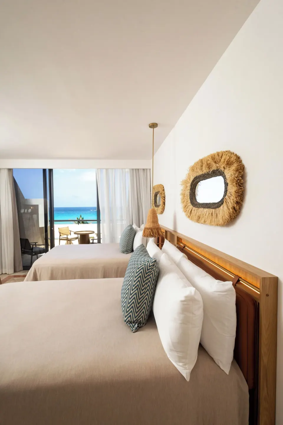 Guest room with two beds and a balcony view of the sea at Paradisus Cancún.