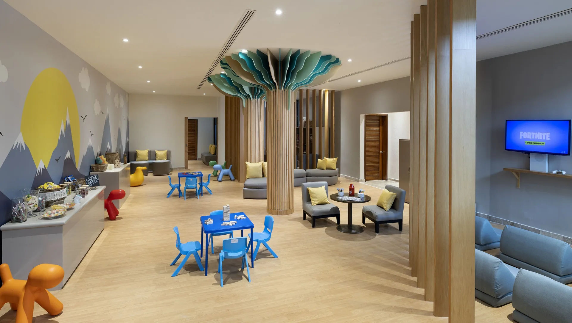 Kids activity lounge with small tables, seating, and game screen at Paradisus Cancún.