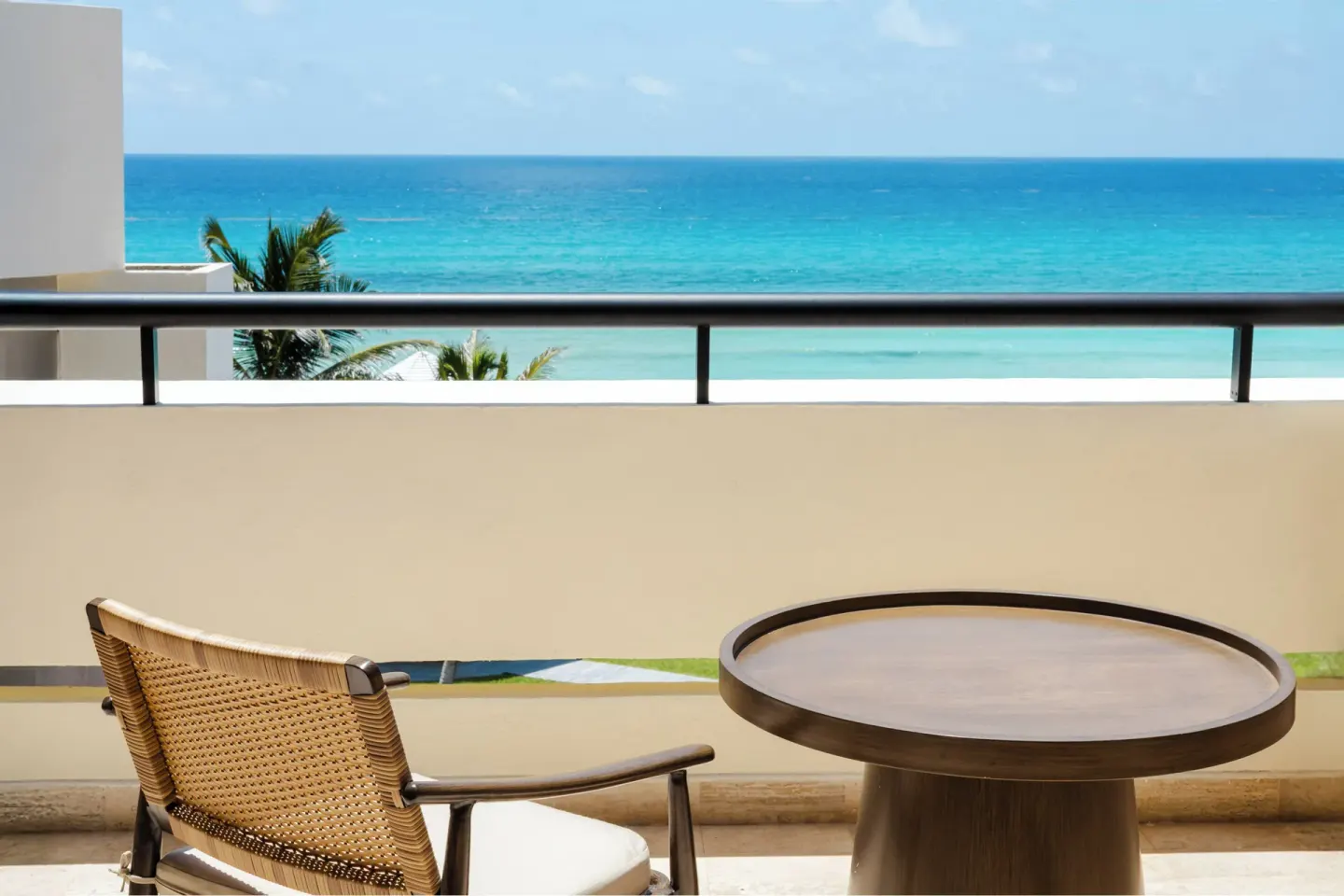 Balcony seating at Paradisus Cancún with a round table and ocean view beyond the railing.