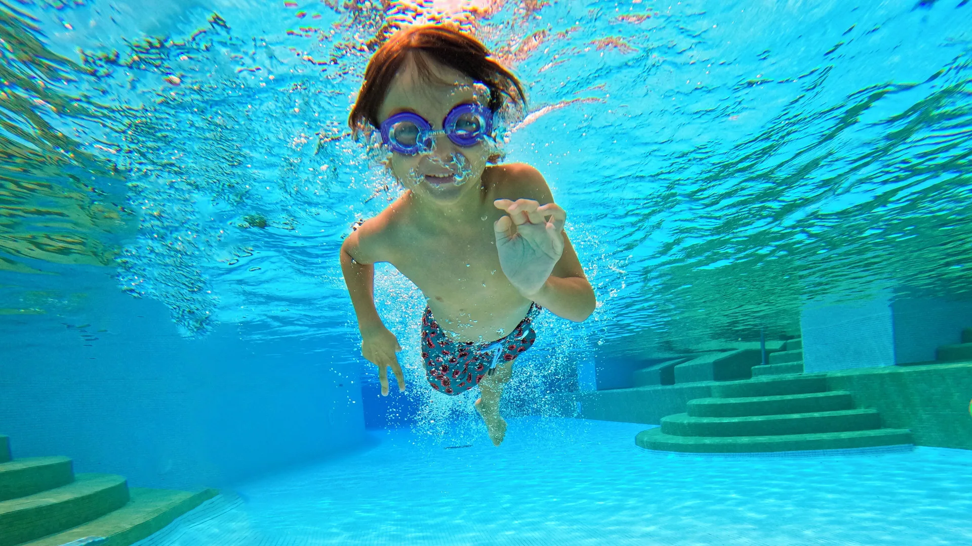 Child swimming underwater with goggles in a pool at Paradisus Cancún.