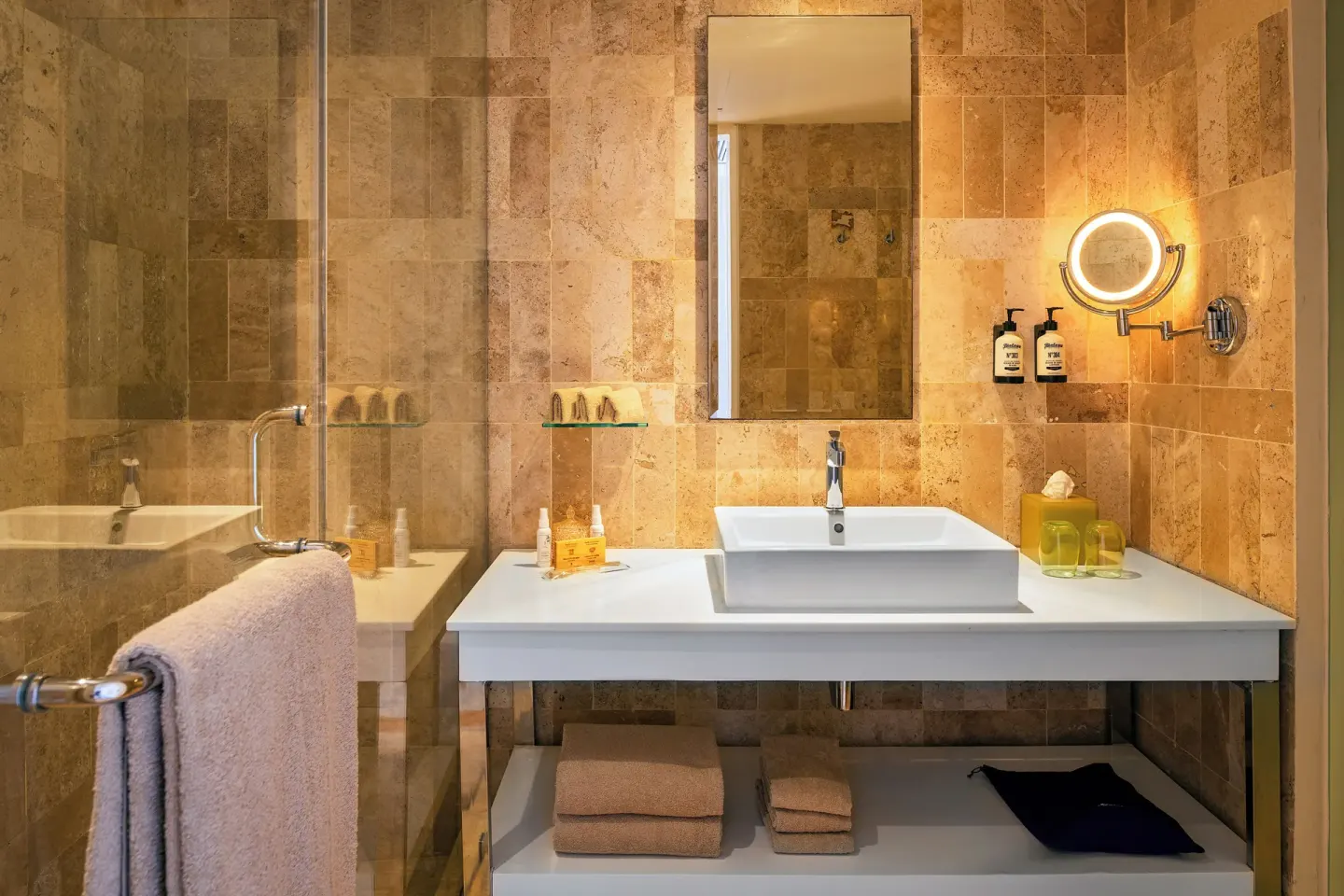 White bathroom vanity with glass shower and wall mirror at Paradisus Cancún.