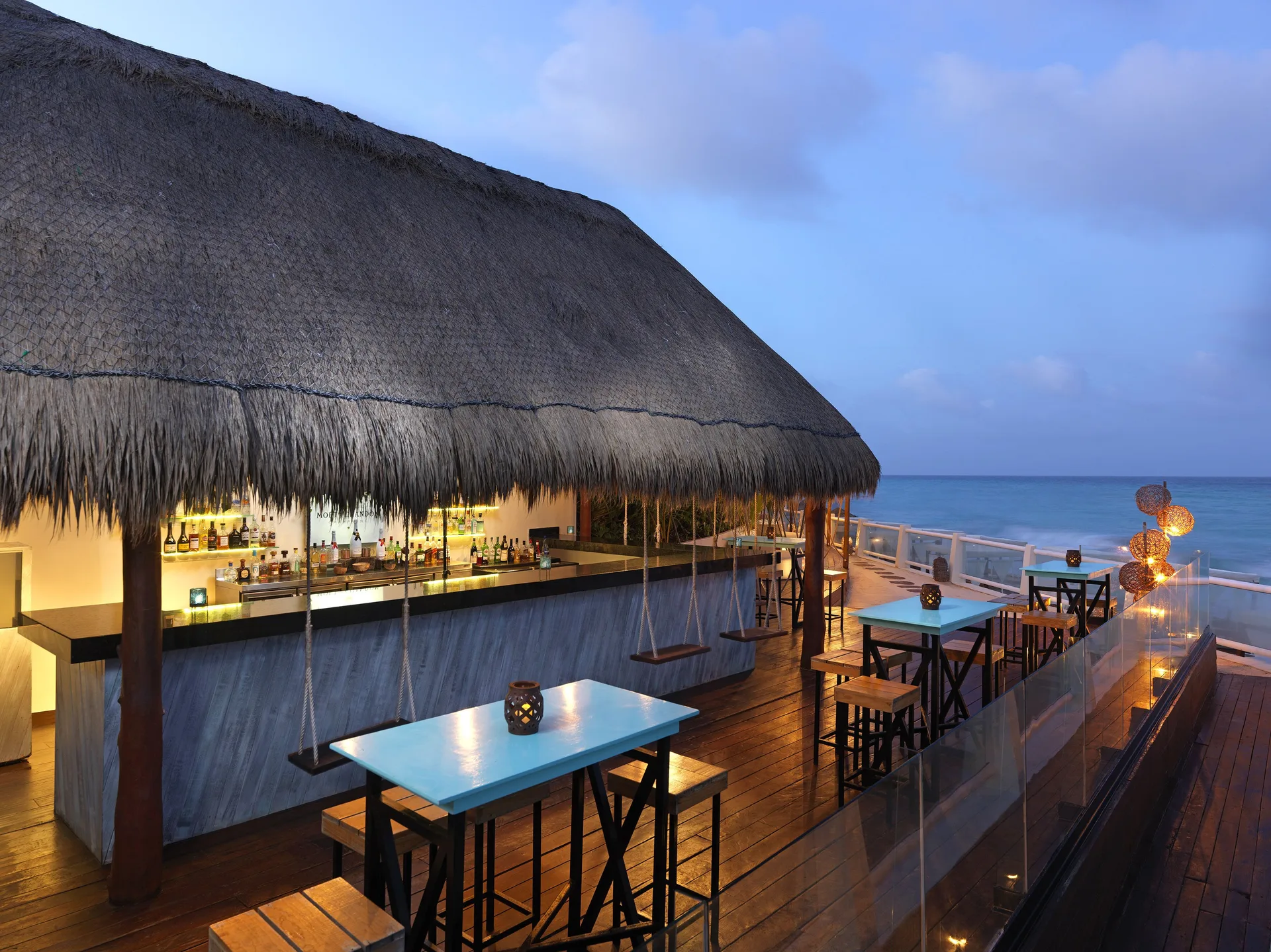 A thatched rooftop bar terrace overlooks the ocean at Paradisus Cancún.