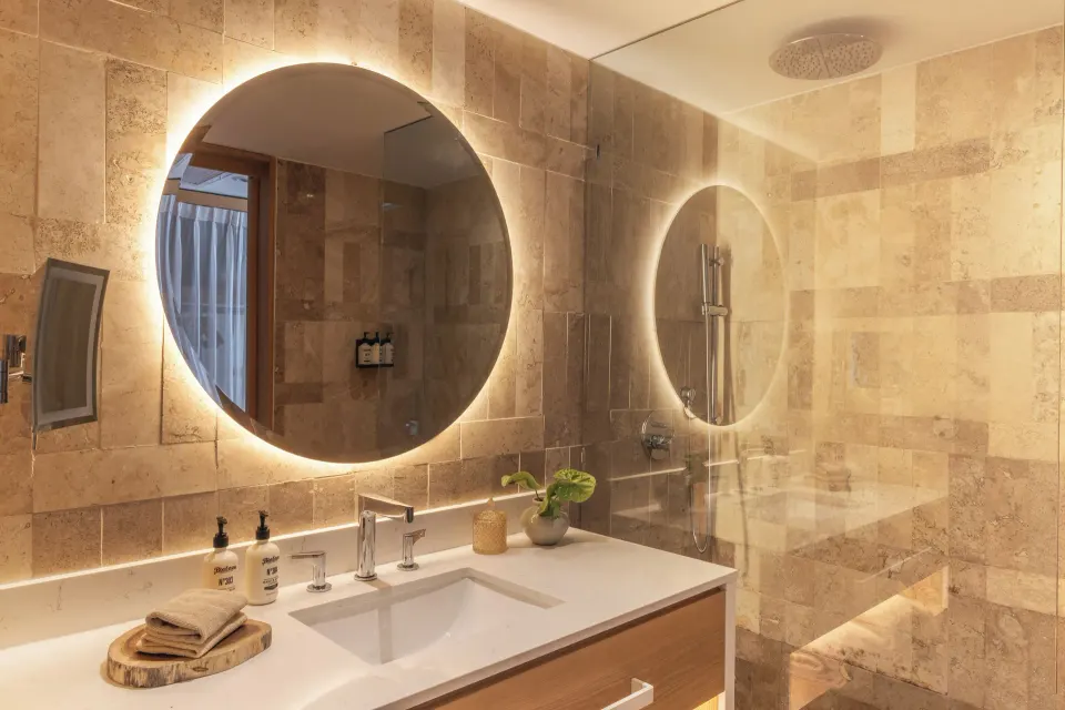 Family Concierge Junior Suite Sunset View bathroom with lit round mirror at Paradisus Cancún.