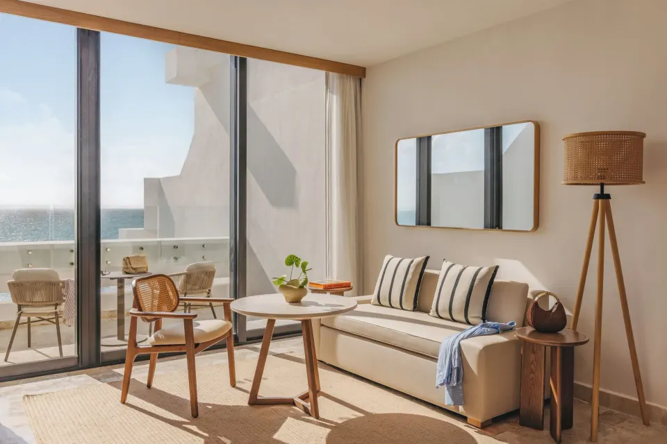 Sitting area and balcony in a Family Concierge Suite Ocean View at Paradisus Cancún.
