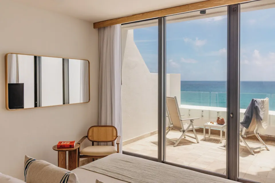 Family Concierge Two Bedroom Ocean View bedroom at Paradisus Cancún opening to an ocean-view terrace.