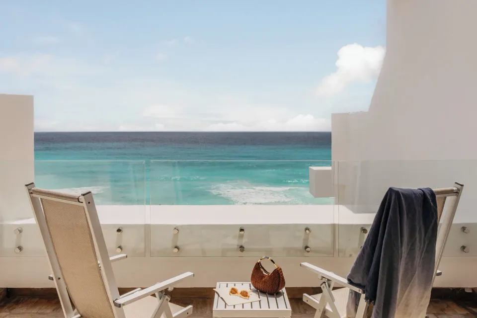 Junior Suite Ocean View balcony chairs overlooking turquoise sea at Paradisus Cancún.