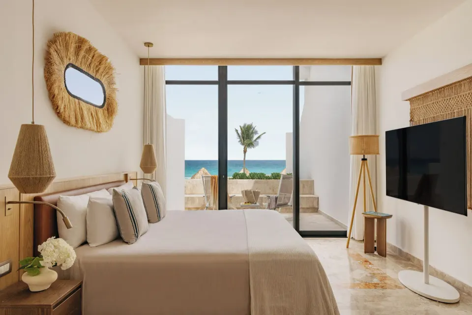 Junior Suite Ocean View bedroom with king bed and balcony at Paradisus Cancún.