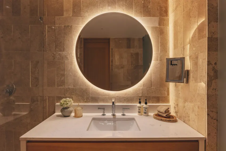 Junior Suite bathroom vanity with round mirror at Paradisus Cancún.