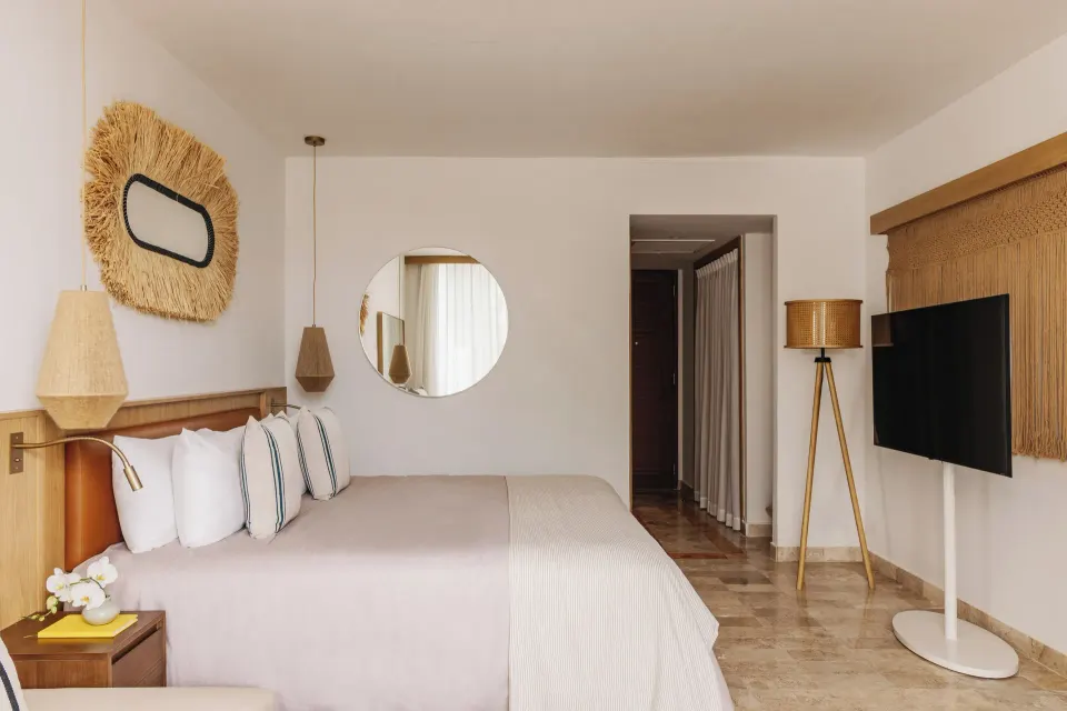 Junior Suite Sunset View king bed and TV area at Paradisus Cancún.