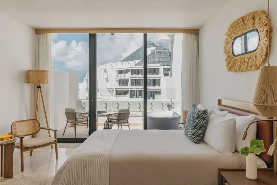Premium Suite Sunset View bedroom with balcony tub at Paradisus Cancún.