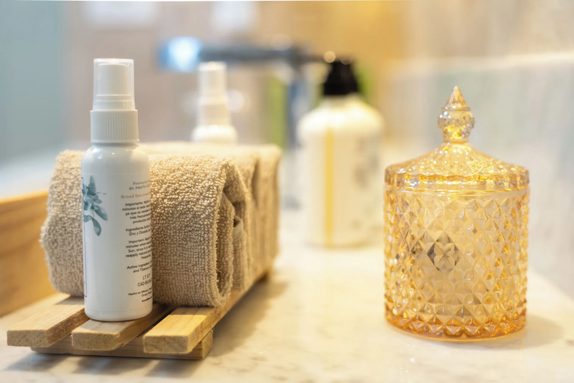 Bathroom counter with toiletries, towels and amber jar in The Reserve Suite at Paradisus Cancún.