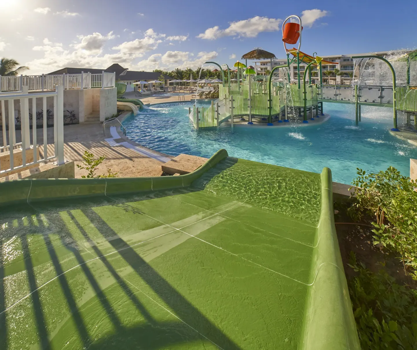Green waterslide facing a splash play structure at Paradisus Grand Cana.