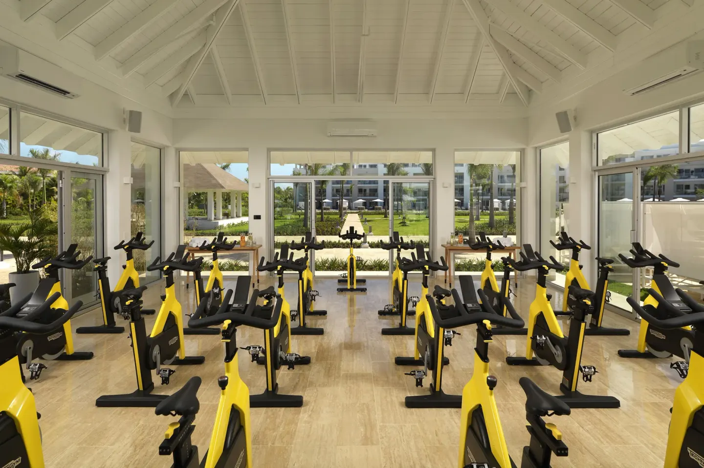 Indoor cycling studio with rows of yellow bikes at Paradisus Grand Cana.