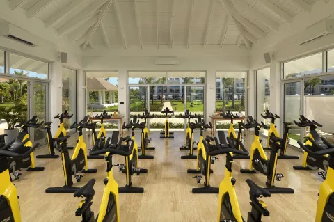 Indoor cycling studio with rows of yellow bikes at Paradisus Grand Cana.