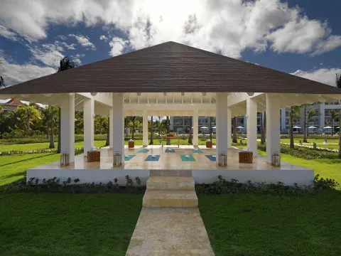 An open-air yoga pavilion with mats set on the lawn at Paradisus Grand Cana.