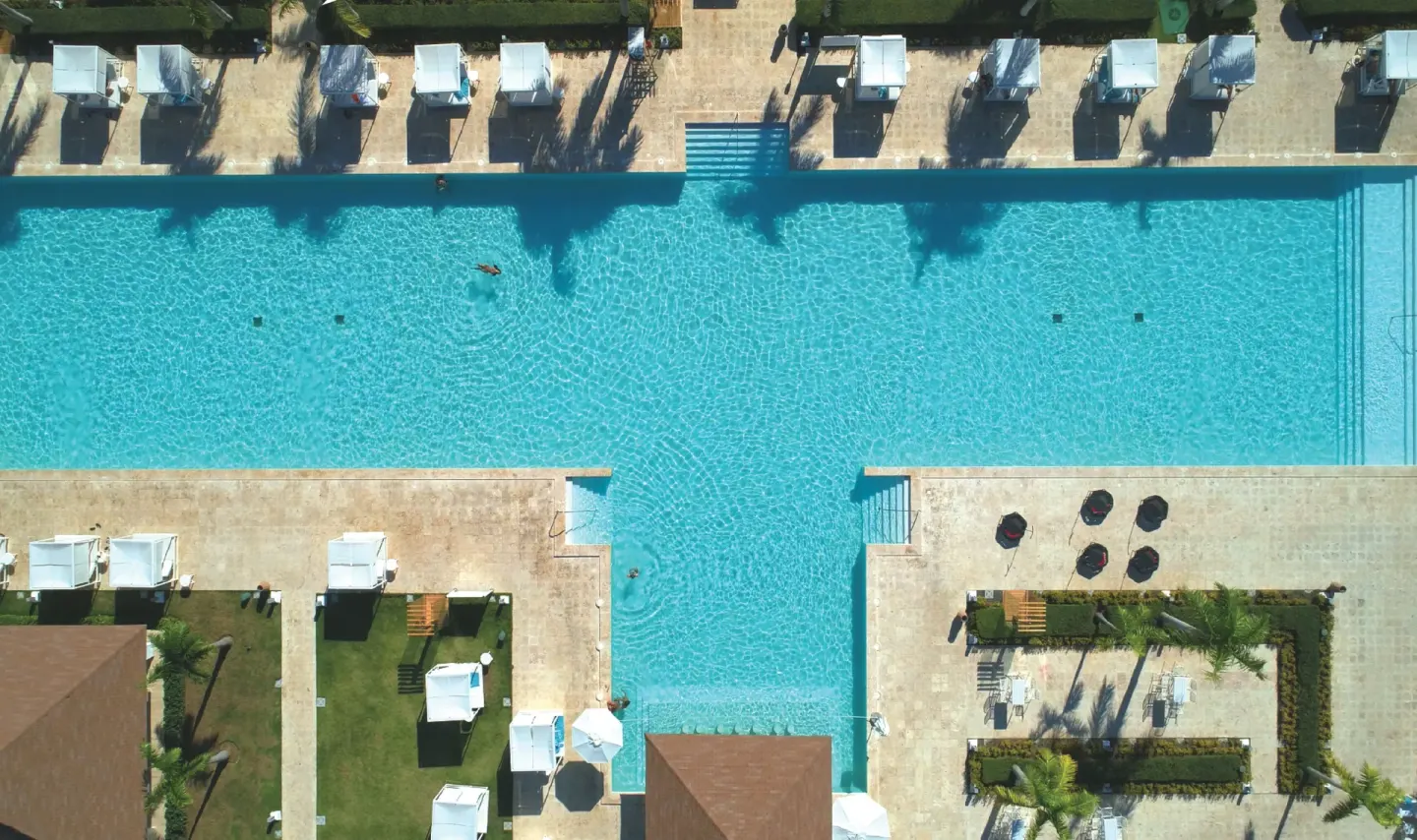Overhead view of a bright resort pool with cabanas at Paradisus Grand Cana.