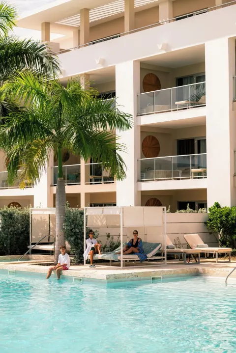 Poolside cabana and balconies beside a resort building at Paradisus Grand Cana.