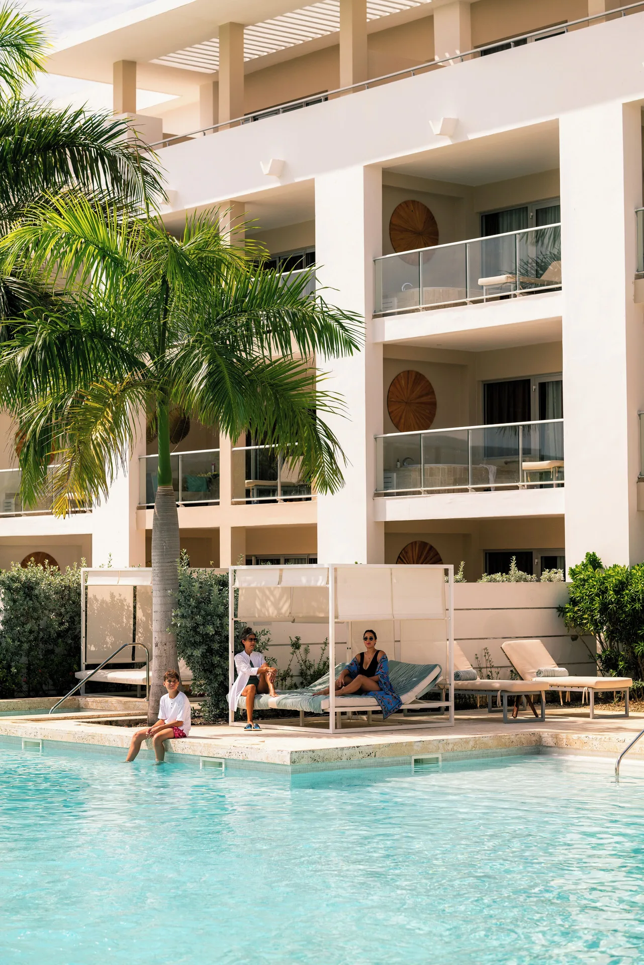 Poolside cabana and balconies beside a resort building at Paradisus Grand Cana.