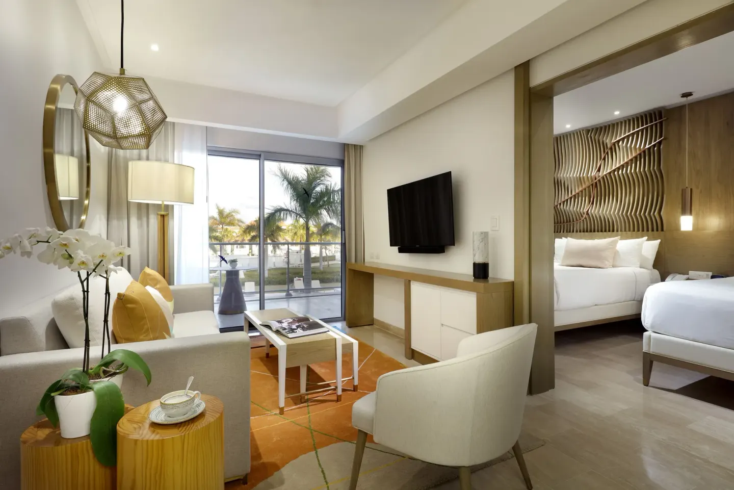 Resort suite sitting area beside a king bedroom at Paradisus Grand Cana.