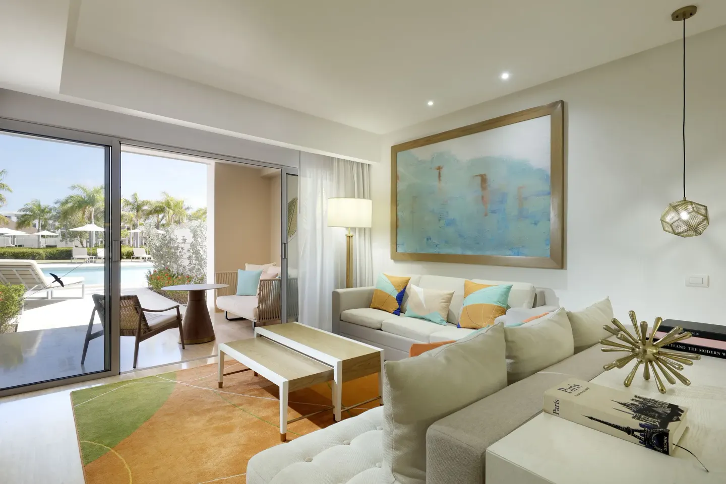 Suite living room with sofa seating and poolside terrace at Paradisus Grand Cana.