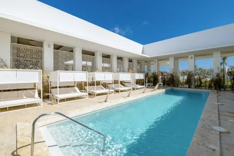 A sunny courtyard pool lined with shaded loungers at Paradisus Grand Cana.