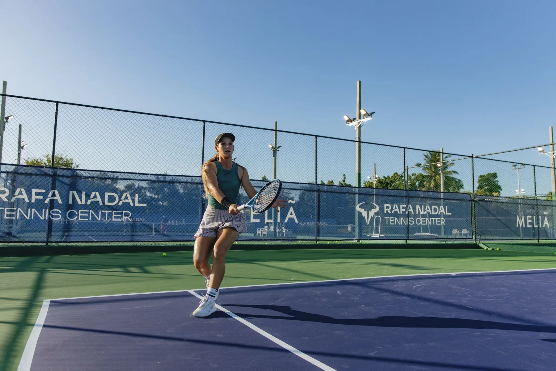 Tennis player preparing to return a shot on court at Paradisus Grand Cana.
