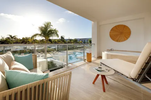 Upper-floor terrace with daybed, tub, and pool view at Paradisus Grand Cana.