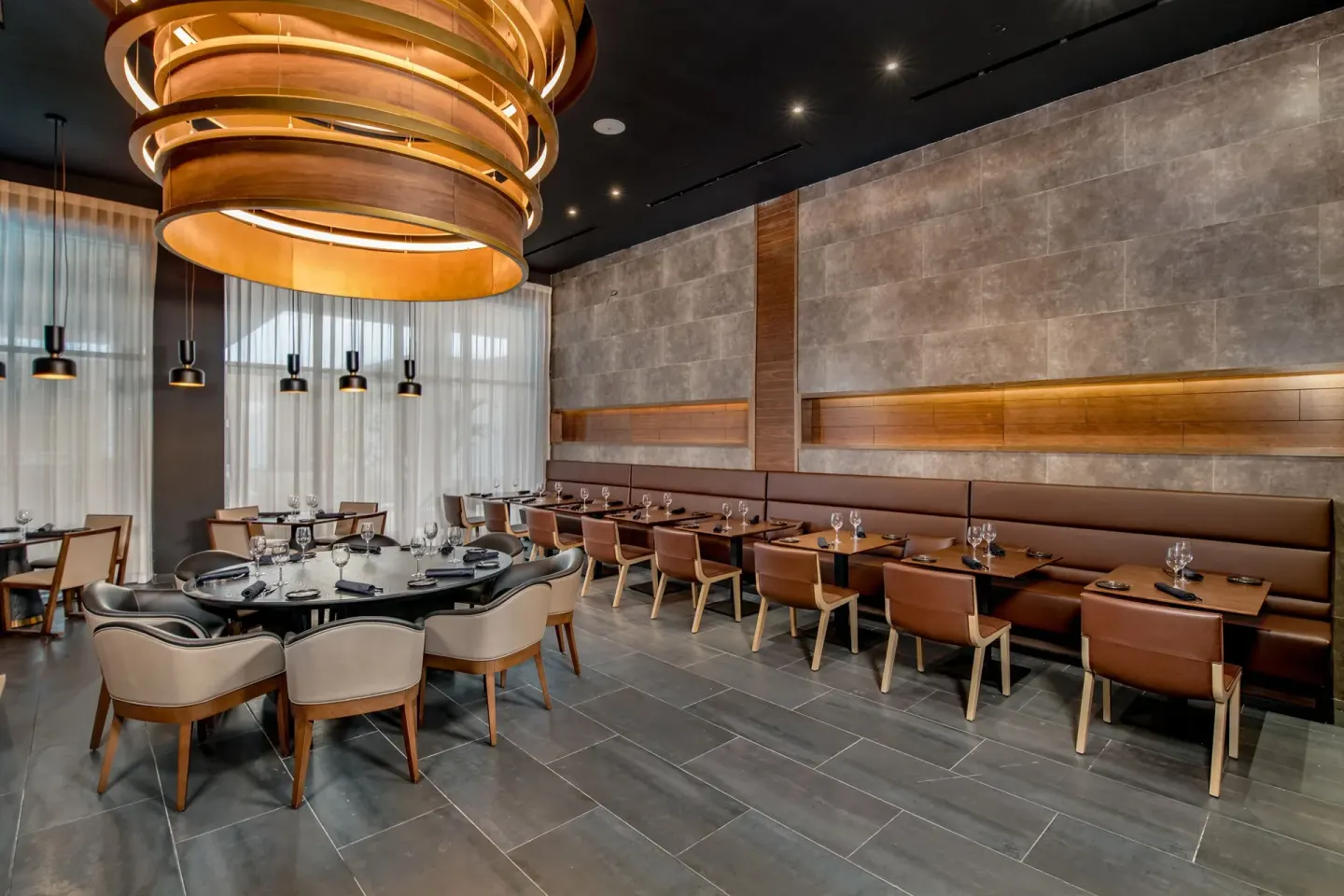 Modern dining room with round chandelier and set tables at Paradisus Grand Cana.