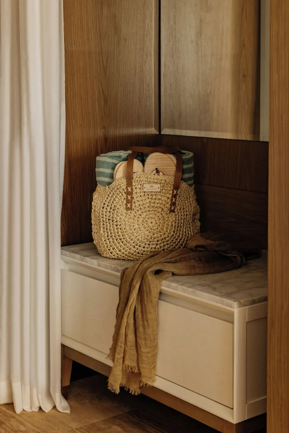 A woven beach bag on a marble-topped bench in the Family Concierge Master Suite at Paradisus Grand Cana.