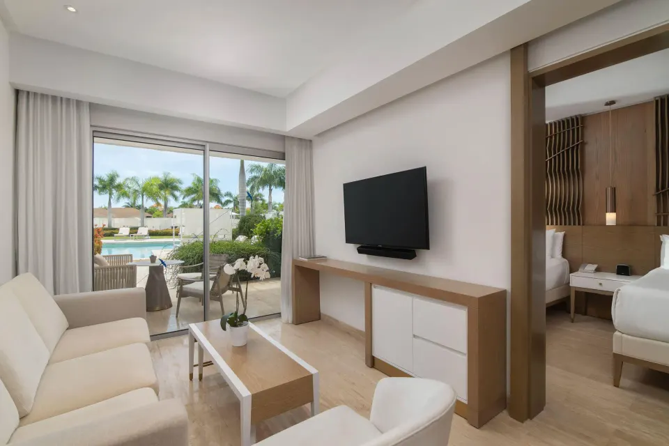 Suite living room with bedroom doorway and swim-up terrace at Paradisus Grand Cana.