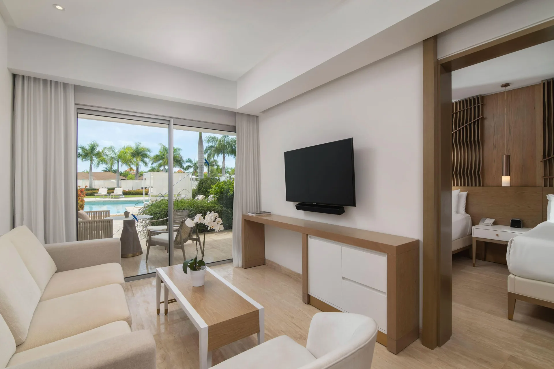 Suite living room with bedroom doorway and swim-up terrace at Paradisus Grand Cana.