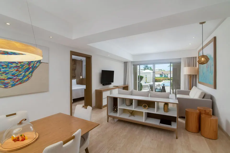 Open living room and dining area with pool terrace view at Paradisus Grand Cana.