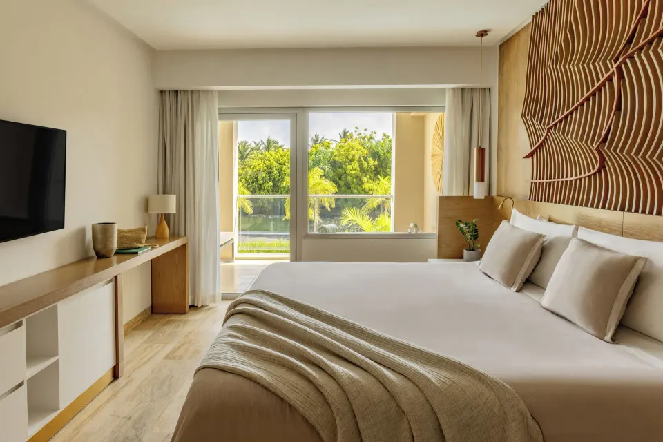 One Bedroom Master Suite bedroom with king bed and balcony greenery at Paradisus Grand Cana.