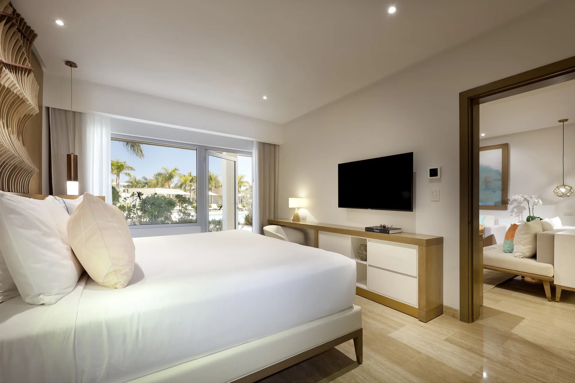 Master Swim-Up Suite king bed, TV, and sitting room doorway at Paradisus Grand Cana.