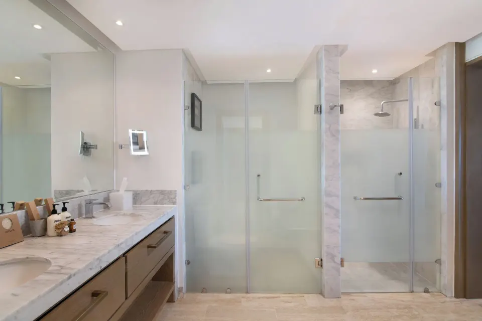 Swim-up suite bathroom at Paradisus Grand Cana with double vanity and glass showers.