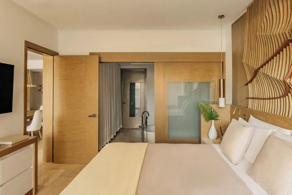 Two Bedroom Master Suite bedroom with king bed and wood accents at Paradisus Grand Cana.