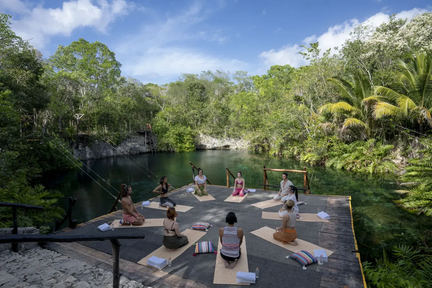 A yoga group practices beside a cenote at Paradisus La Perla Riviera Maya.