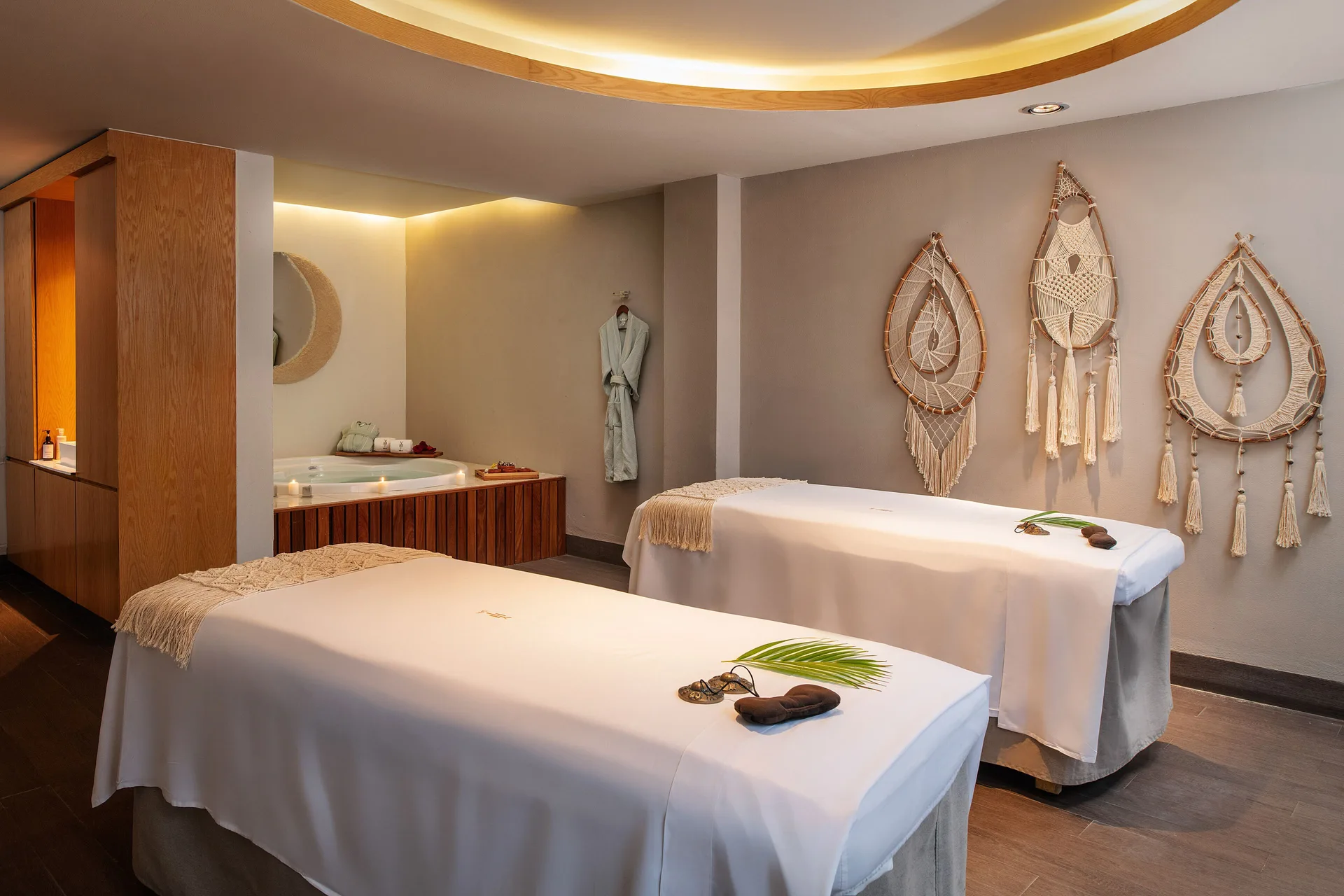 Two spa treatment tables with wall decor at Paradisus La Perla Riviera Maya.