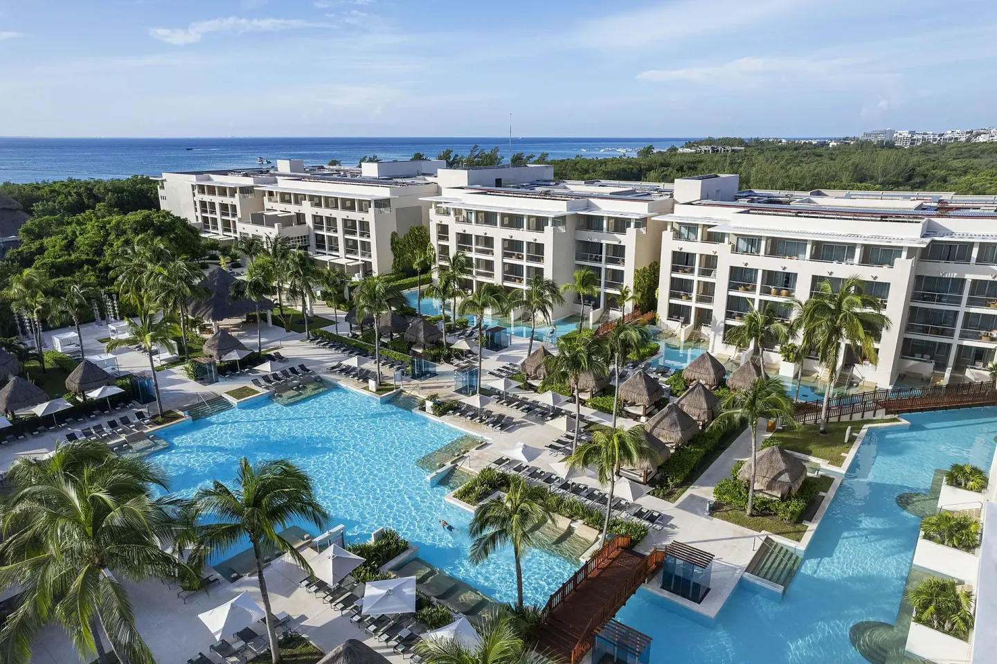 Elevated view of pools, palms, and resort buildings at Paradisus La Perla Riviera Maya.