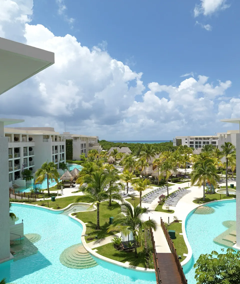 Elevated view of pools, palms, pathways, and ocean at Paradisus La Perla Riviera Maya.