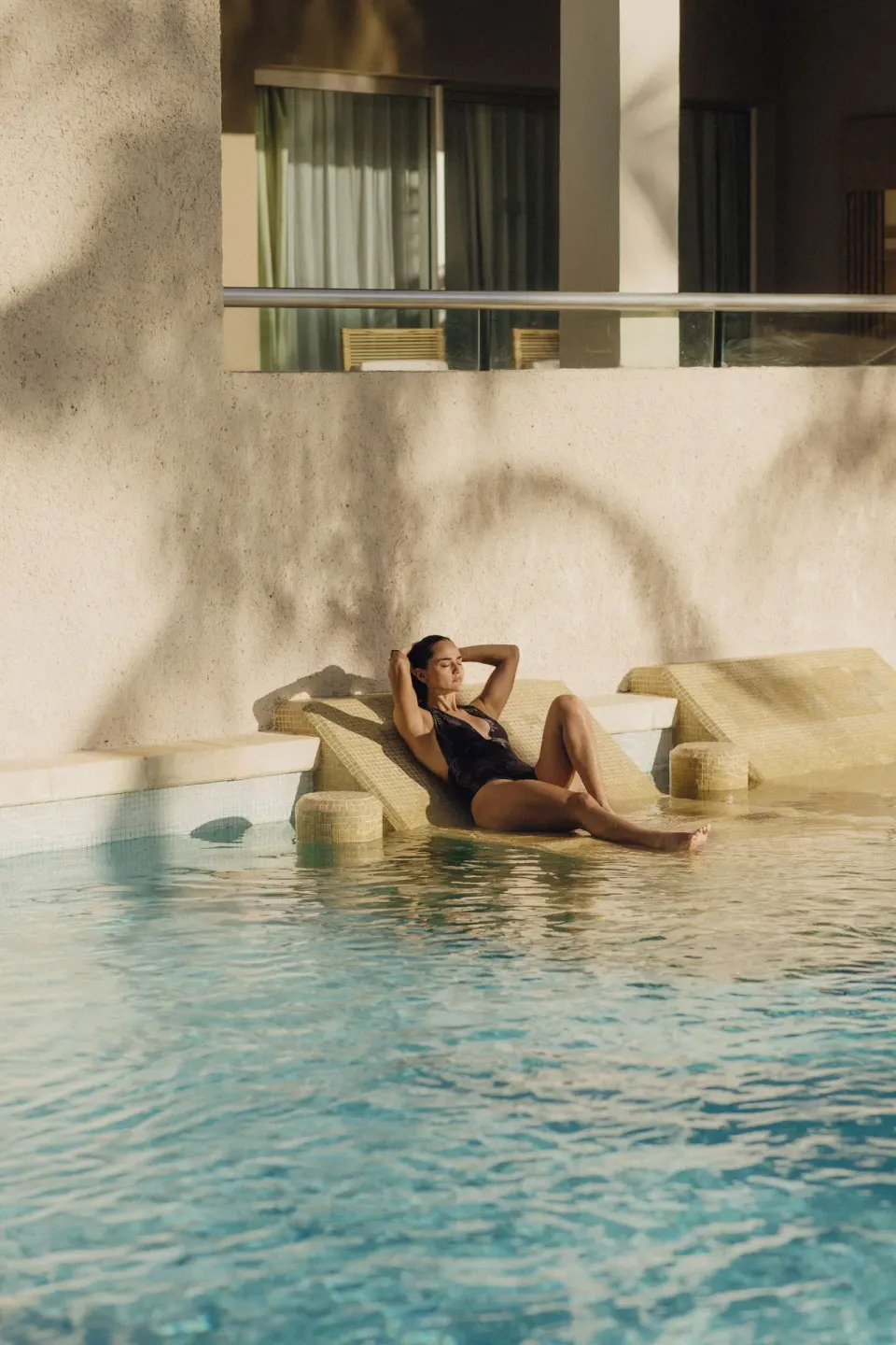Guest reclines on an in-water lounger at the pool at Paradisus La Perla Riviera Maya.