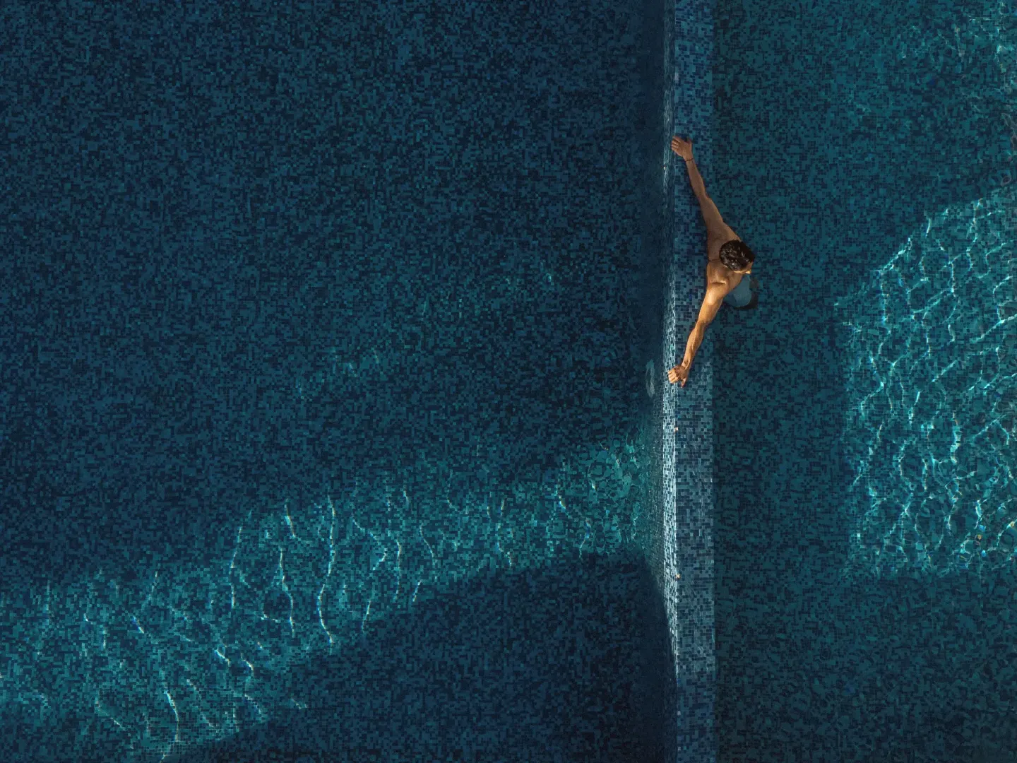 Overhead view of a swimmer in a blue mosaic pool at Paradisus La Perla Riviera Maya.