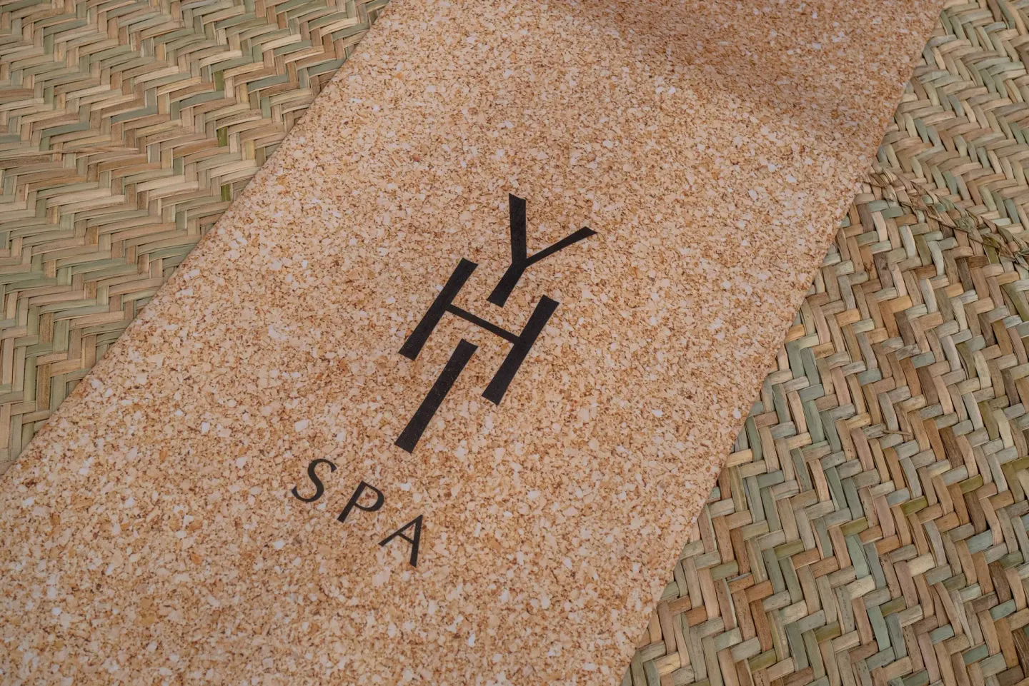 A spa mat with a printed spa logo rests on woven flooring at Paradisus La Perla Riviera Maya.