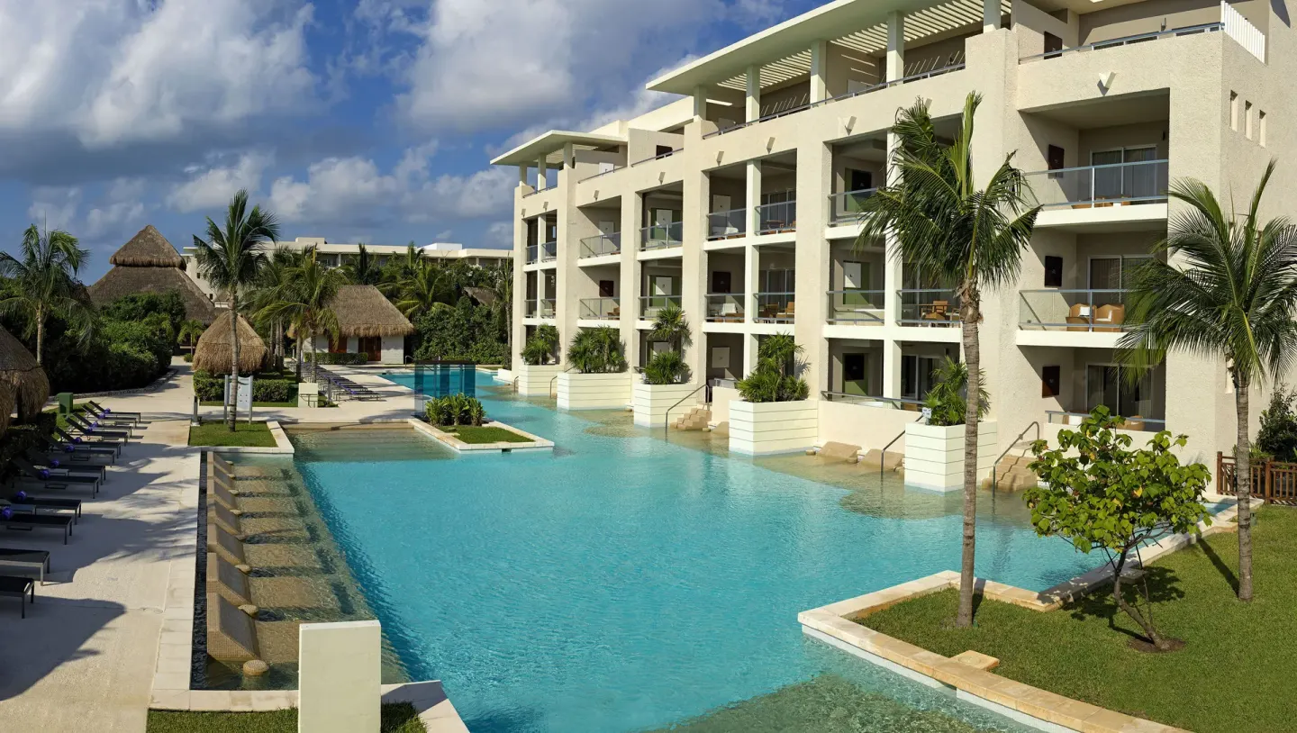 Wide view of a swim-up pool and guest-room balconies at Paradisus La Perla Riviera Maya.